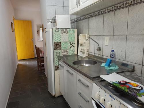 een keuken met een wastafel en een koelkast bij CONDOMINIO COLONIAL APARTAMENTOS 150M DA PRAIA in Bombinhas