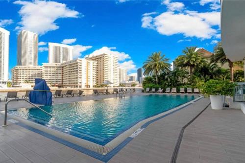 a swimming pool with a city skyline in the background at Designer Beachfront Apartment Views, Luxury & Full Kitchen 805 A in Hallandale Beach