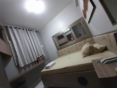 um pequeno quarto com uma cama e um espelho em Motel reality em São Paulo