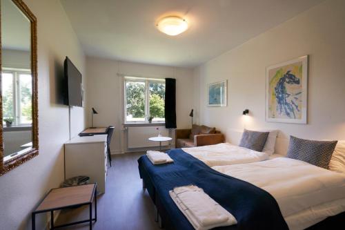 a hotel room with two beds and a mirror at Hotel Skanderborghus in Skanderborg