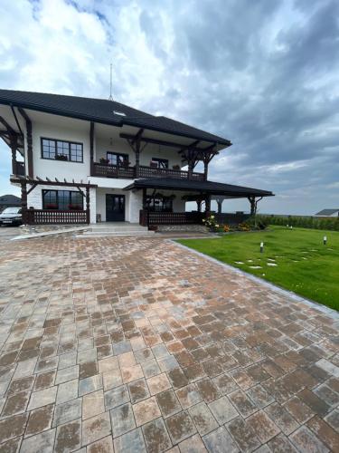 a large white building with a large patio at Livada Bucovinei in Horodnic de Sus