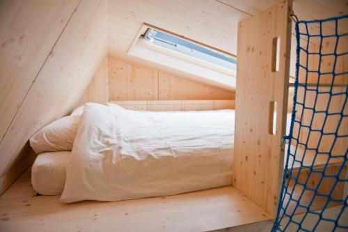 a bed in a small room with a window at Tiny House Pioneer 5 - Green Tiny Village Harz in Osterode