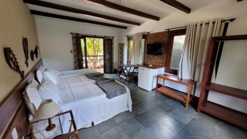 a bedroom with a bed and a desk and a television at Taipabas Hotel in Barra Grande