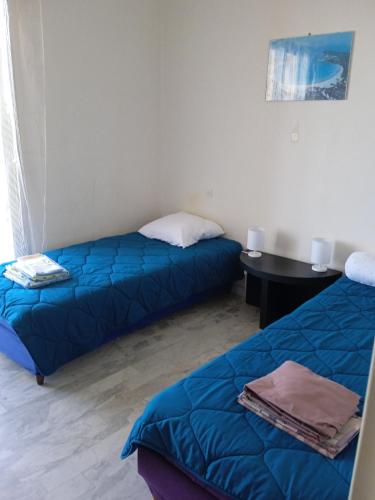 Cette chambre comprend deux lits et un bureau avec une table. dans l'établissement Appartement Climatisé Vue Mer Route des Sanguinaires, à Ajaccio