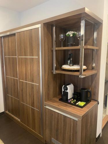 a wooden cabinet with a coffee maker in a room at Hotel Cataleya in Almere