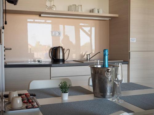 a kitchen with a table with a bucket on a counter at Tisza-tó Apartmanpark in Kisköre