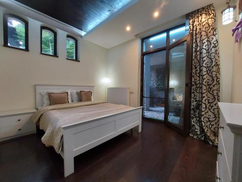 a bedroom with a white bed and a window at Apartamente 13 si 16 in Oxygen Residence Sinaia in Sinaia