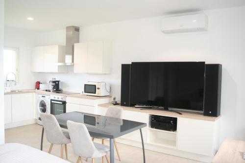 - une cuisine avec une table et une grande télévision dans l'établissement Canigou, gîtes LEFEBVRE, 4* climatisé, table d'hôte, à Los Masos