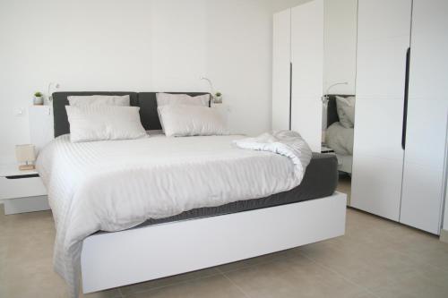 - une chambre blanche avec un grand lit aux murs blancs dans l'établissement Canigou, gîtes LEFEBVRE, 4* climatisé, table d'hôte, à Los Masos