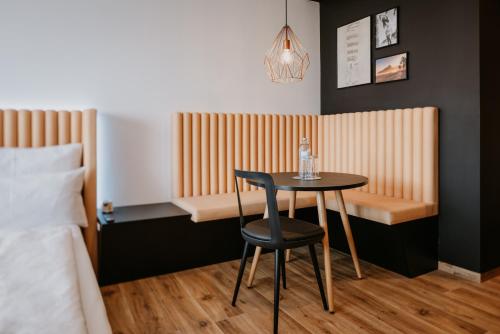 a small table and chair in a room with a bed at Rioca Vienna Posto 2 in Vienna