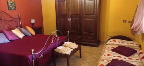 a bedroom with two beds and a chair and a door at Chalet Rustico in Sessa Aurunca