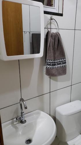 une salle de bain avec un lavabo et un miroir et des toilettes dans l'établissement Apto com Varanda no N Bandeirante , proximo ao Aeroporto, à Brasilia