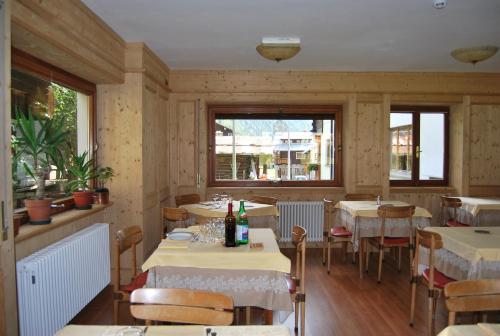 a dining room with tables and chairs and windows at Hotel Cristallo in Macugnaga