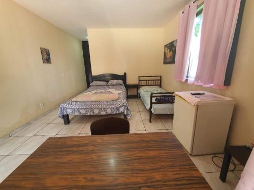 uma sala de estar com duas camas e uma mesa em Espaço La Gondola em Araruama