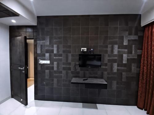 een kamer met een muur met een tv en een muur bij Hotel City Heart Shirdi in Shirdi