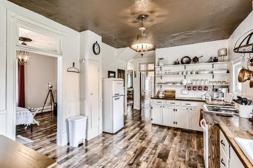 a kitchen with white appliances and wooden floors at The Conductor's House in Cripple Creek