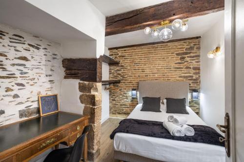 een slaapkamer met een bed en een bakstenen muur bij LE SAINT LOUIS - Apt 3 chambres au cœur de Rennes in Rennes