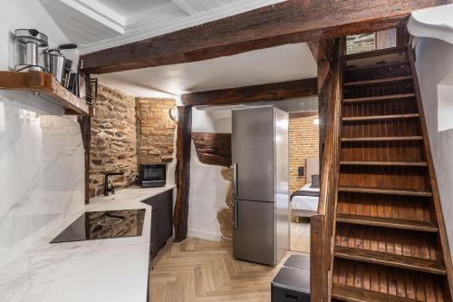 a kitchen with a staircase and a refrigerator in a room at LE SAINT LOUIS - Apt 3 chambres au cœur de Rennes in Rennes