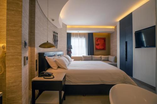 a bedroom with a large bed and a couch at Tribe Hotel, Nairobi, a Member of Design Hotels in Nairobi
