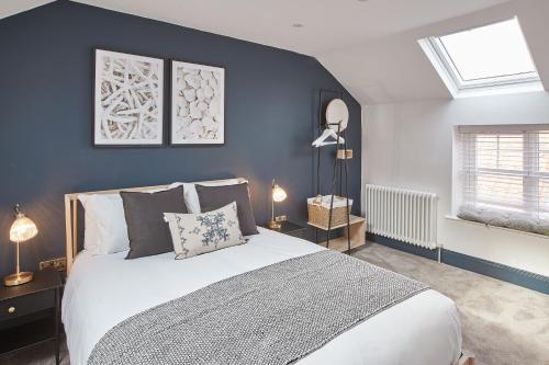een slaapkamer met een bed en een blauwe muur bij Host & Stay - Grumbles Cottage in Whitby
