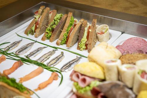 Una bandeja llena de sándwiches, carnes y verduras. en Elia Agia Marina Hotel, en Agia Marina de Nea Kydonia