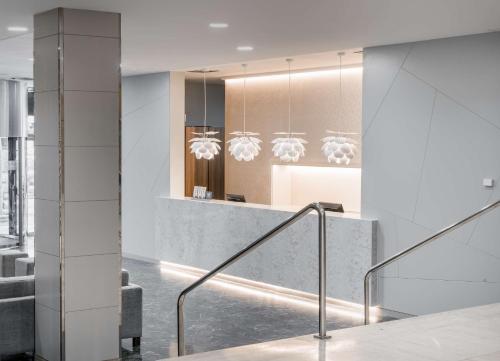 a lobby with a staircase and a reception desk at NH Ciudad Real in Ciudad Real