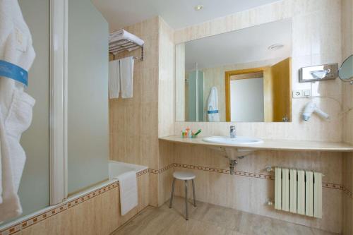 y baño con lavabo y ducha. en Hotel NH Ciudad Real, en Ciudad Real