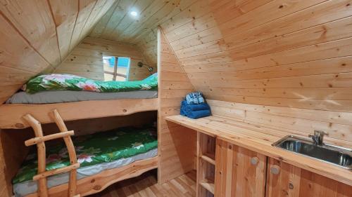 two bunk beds in a wooden cabin with a sink at Pihlaka Jahimaja 