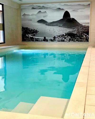 a swimming pool in a hotel room with a mural of a city at Résidence Service Séniors Montana in Angoulême