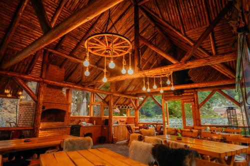 un gran edificio de madera con mesas y sillas. en Casa Cheile Dâmbovicioarei - Cabana 1, en Dîmbovicioara