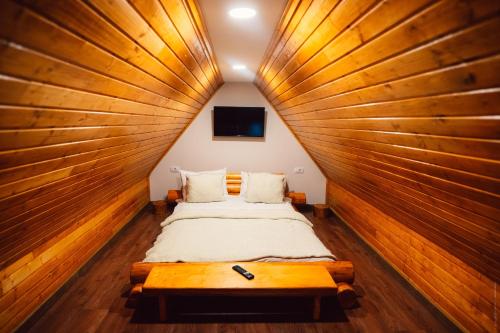 a room with two beds in a wooden wall at Casa Cheile Dâmbovicioarei - Cabana 1 in Dîmbovicioara