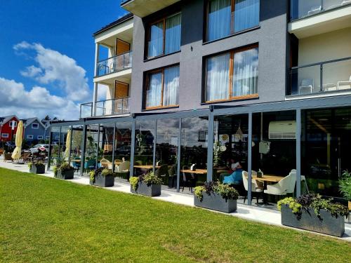 a building with windows and tables and chairs at Apartamenty Przystanek Plaża Sarbinowo in Sarbinowo