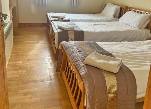 um grupo de três camas num quarto em Castle Quay Holiday Homes em Kinsale