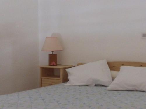 a bedroom with a bed with two pillows and a lamp at Appartement Mont-Dore, 2 pièces, 4 personnes - FR-1-415-8 in Le Mont-Dore