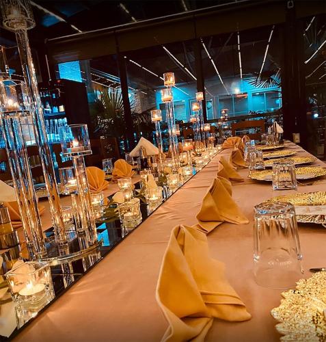 a long table with yellow napkins and glasses on it at Bianca Hotel & Villa in Tirana