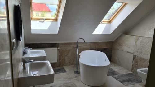 a bathroom with a sink and a toilet and a skylight at The Gusto apartmán in Chomutov