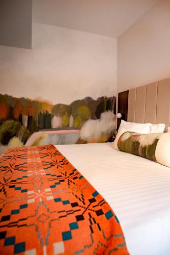 a bedroom with two beds with an orange and blue blanket at Lace Market Hotel in Nottingham