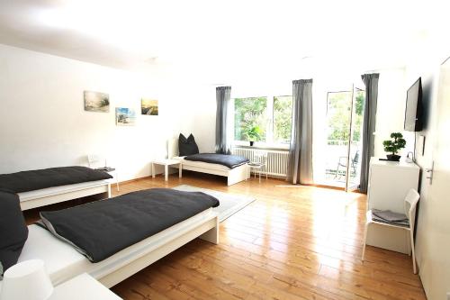 um quarto branco com 2 camas e uma televisão em Spacious Apartment with Balcony em Wetzlar