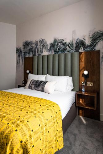 a bedroom with a large bed with a yellow blanket at Lace Market Hotel in Nottingham