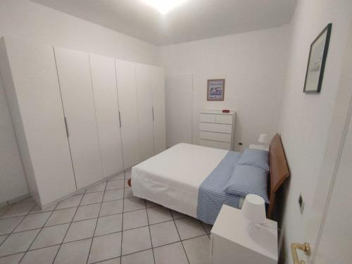 Appartamento La Fisarmonica Recanati في ريكاناتي: غرفة نوم صغيرة بها سرير ودواليب بيضاء