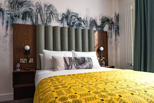 a bedroom with a large bed with a yellow blanket at Lace Market Hotel in Nottingham