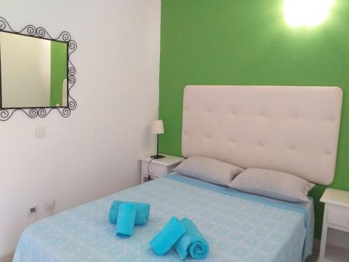 コスタ・デル・シレンチオにあるGreen Holidayのベッドルーム1室(青いタオル付きのベッド1台付)