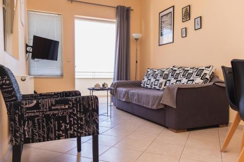 a living room with a couch and a chair at Sunday Apartments in Nafplio