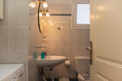 ナフプリオにあるSunday Apartmentsのバスルーム(洗面台、トイレ付)、窓が備わります。