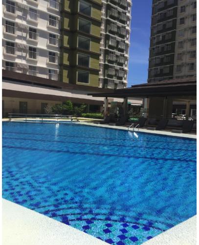 a large swimming pool next to some tall buildings at Jenny's Cozy Place with Wifi in Mandaue City