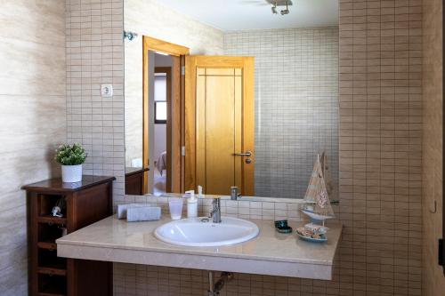 y baño con lavabo y espejo. en Ideal for family holidays, near beach and golf- Casa James, en La Guirra
