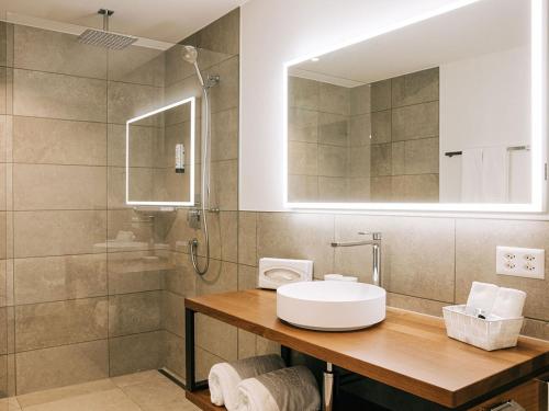 a bathroom with a sink and a shower at Hotel Krone Thun in Thun