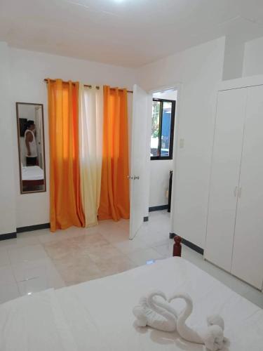a room with a bed with a swan on the floor at Luna Oslob Travellers Inn in Oslob
