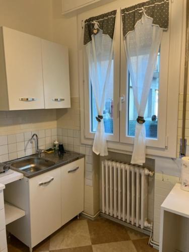 kuchnia ze zlewem oraz okno z zasłonami w obiekcie La casa sui colli bolognesi w mieście Savigno