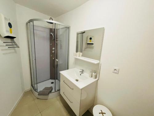 uma casa de banho branca com um chuveiro e um lavatório. em Zewwelatreppler - La Grange aux Petits Oignons - Chambre Cigogne em Sélestat